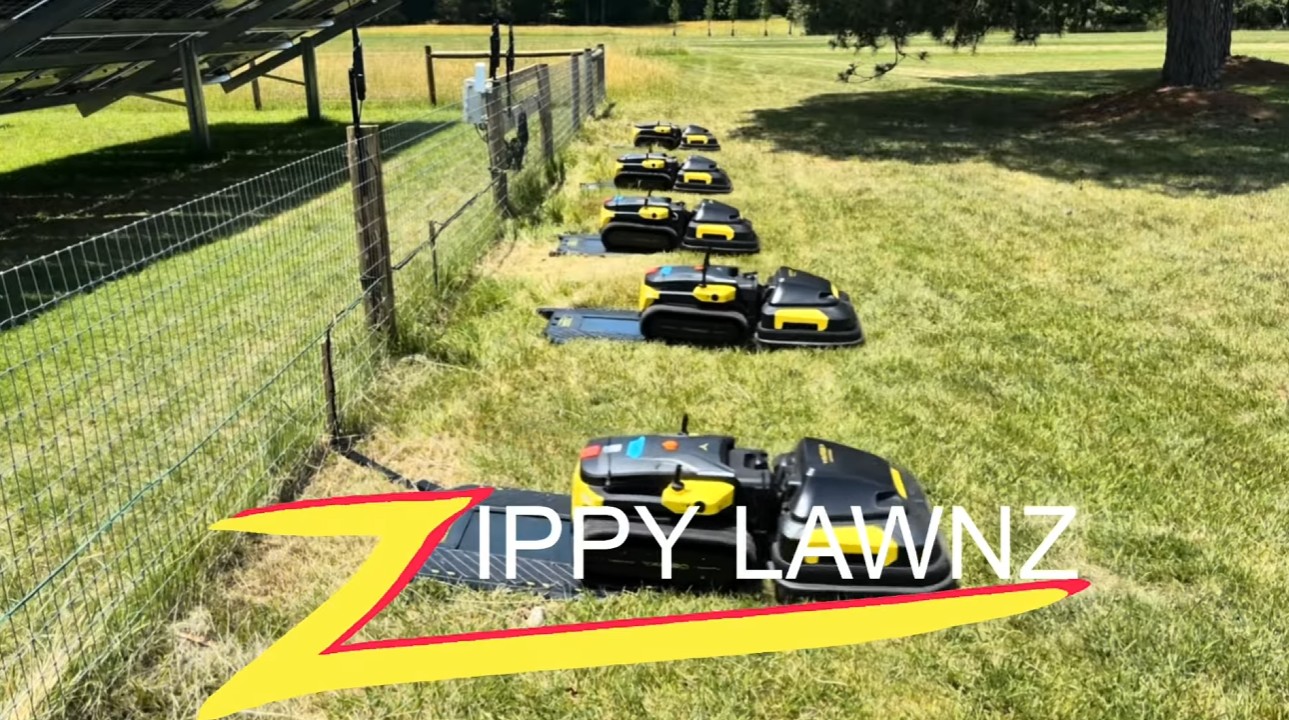 A line of Yarbo tracked robot mowers staged on a large open lawn for a field test