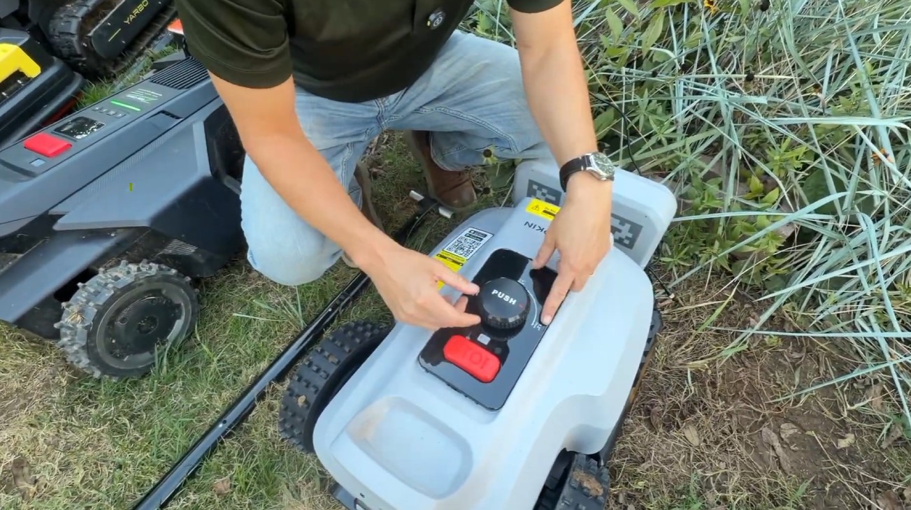 Hands on the Lopkin L2500's push dial for cutting height beside the red STOP button