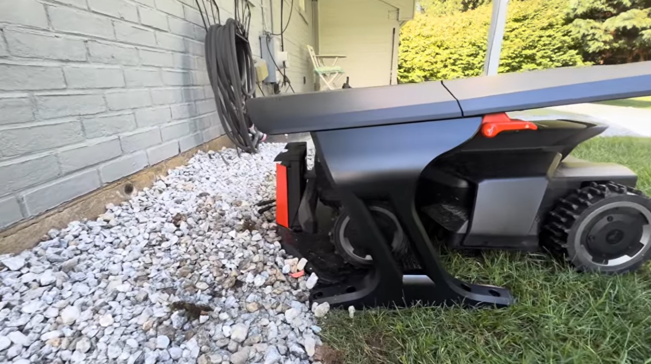 A Navimow charging station set against the side of a house