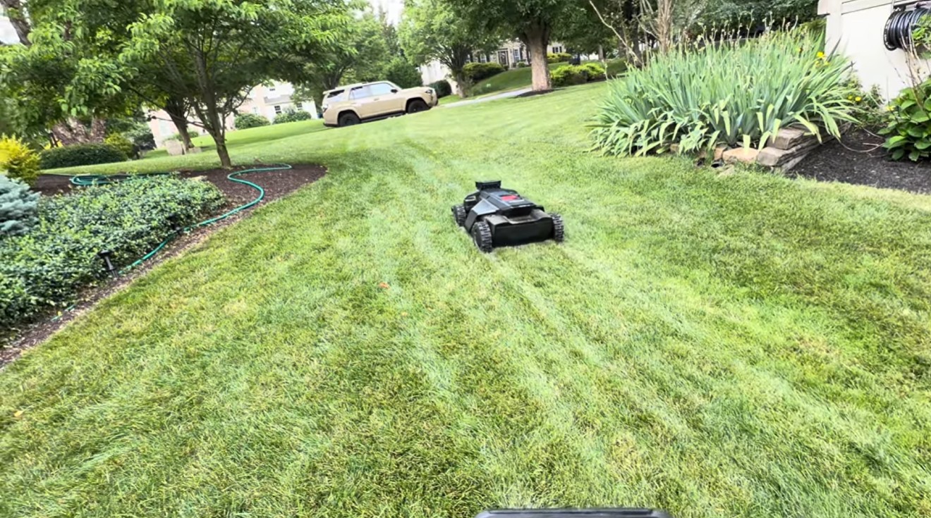 A Segway Navimow X430 robot mower cutting a striped front lawn at a West Chester, PA home