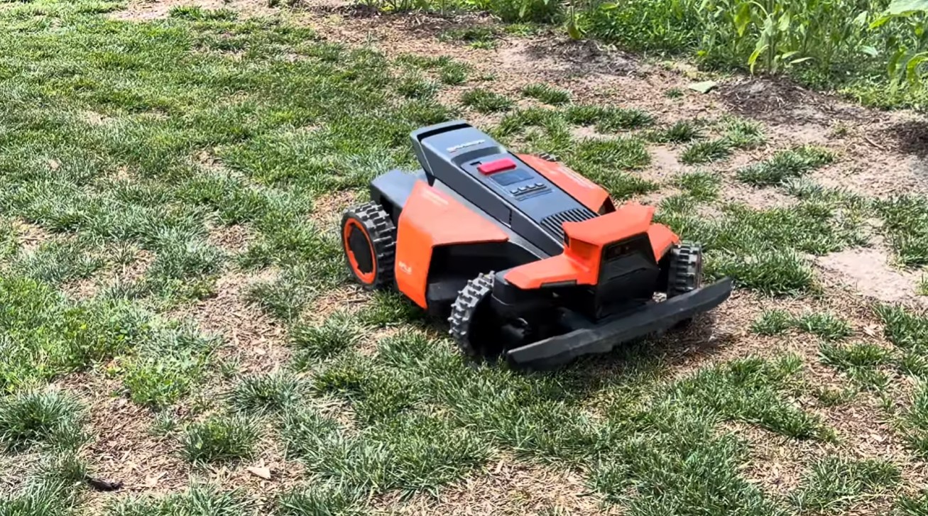 A Zippy Lawnz team member with a Segway Navimow Terranox commercial robot mower and RTK setup poles