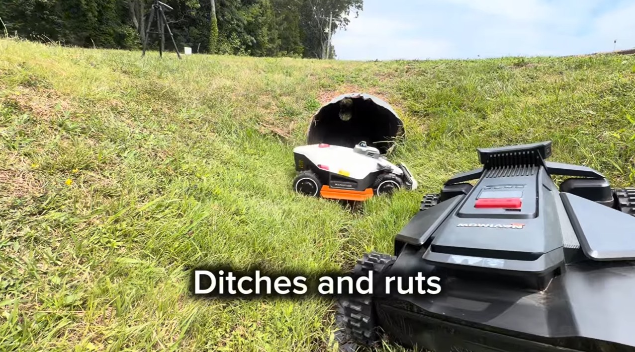 A Mammotion LUBA 3 and a Segway Navimow X430 side by side in a rough grassy ditch during a field test