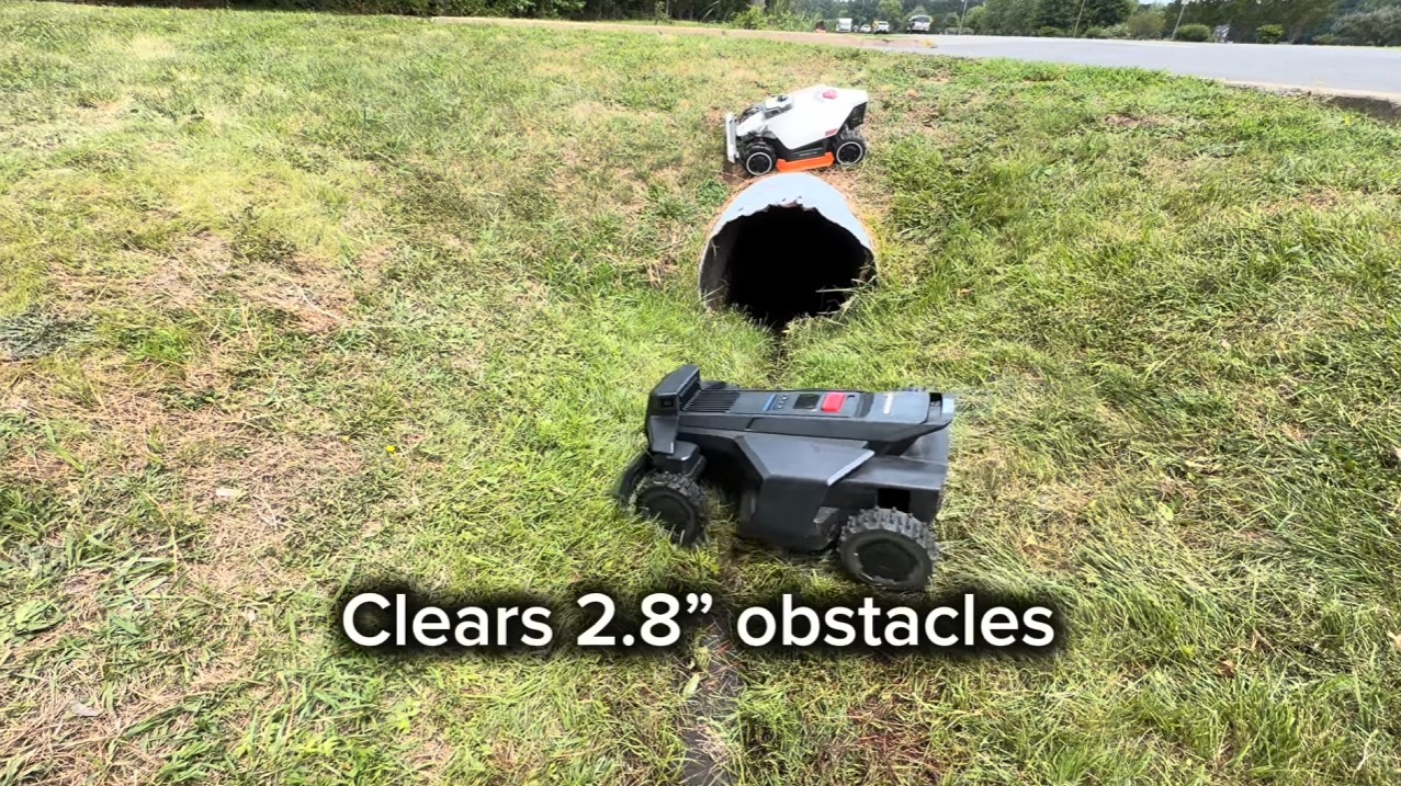 A Segway Navimow X430 clearing a 2.8-inch obstacle in a grassy ditch