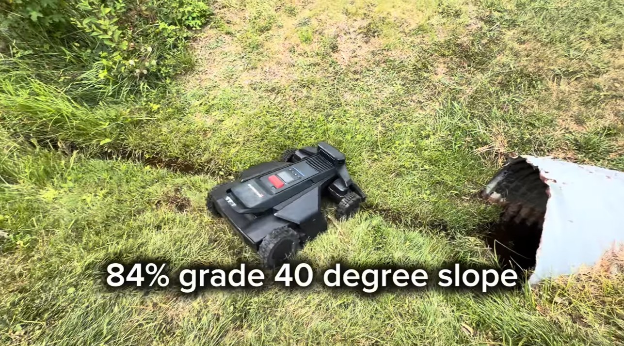A tracked robot mower climbing an 84% grade, 40-degree grassy slope
