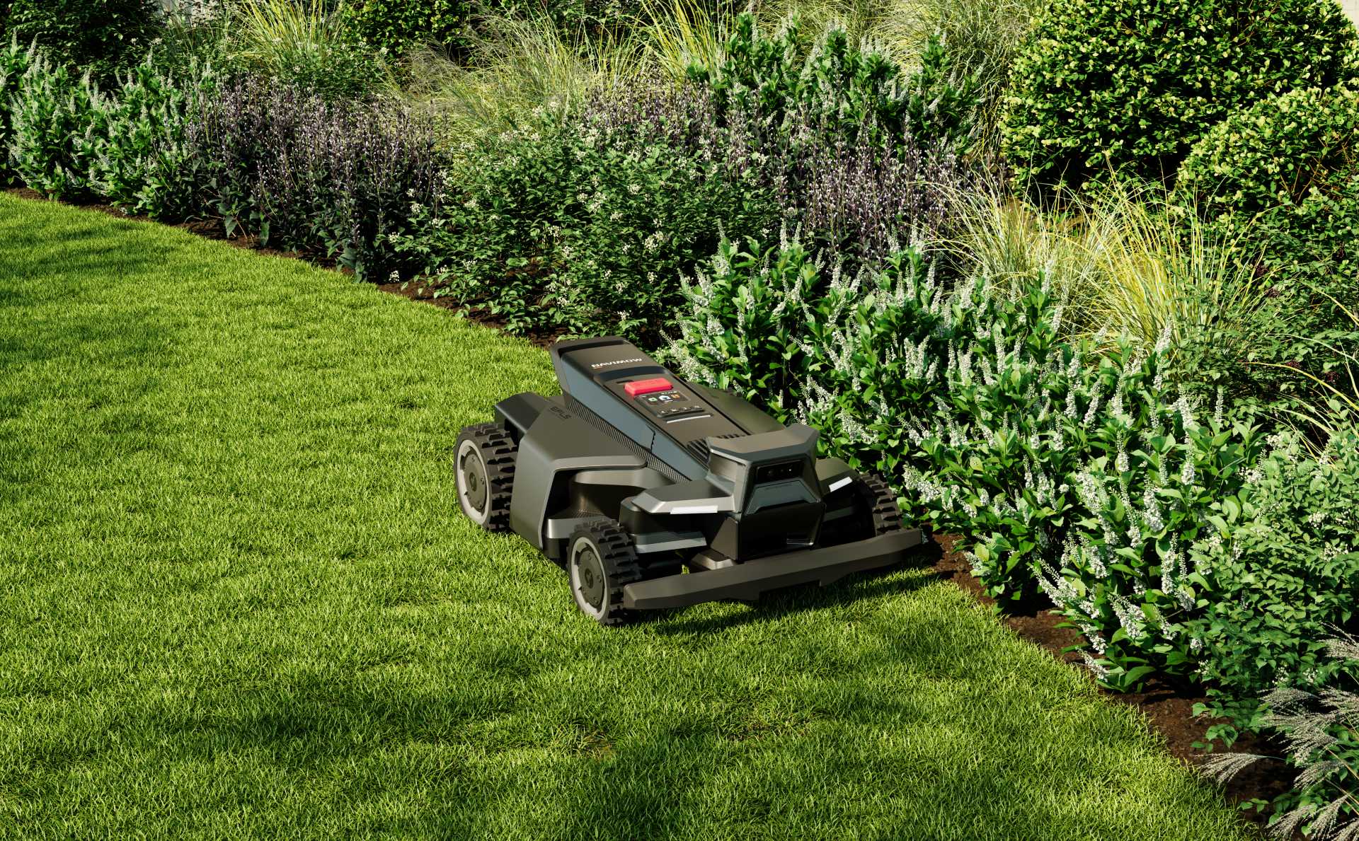 A robotic mower easing along a soft curved bedline beside lush flowering garden beds