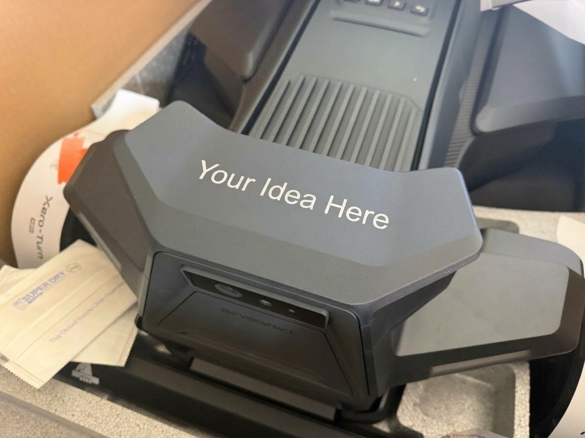 A Segway Navimow X4 in its box, its decorative camera housing printed with the words “Your Idea Here”